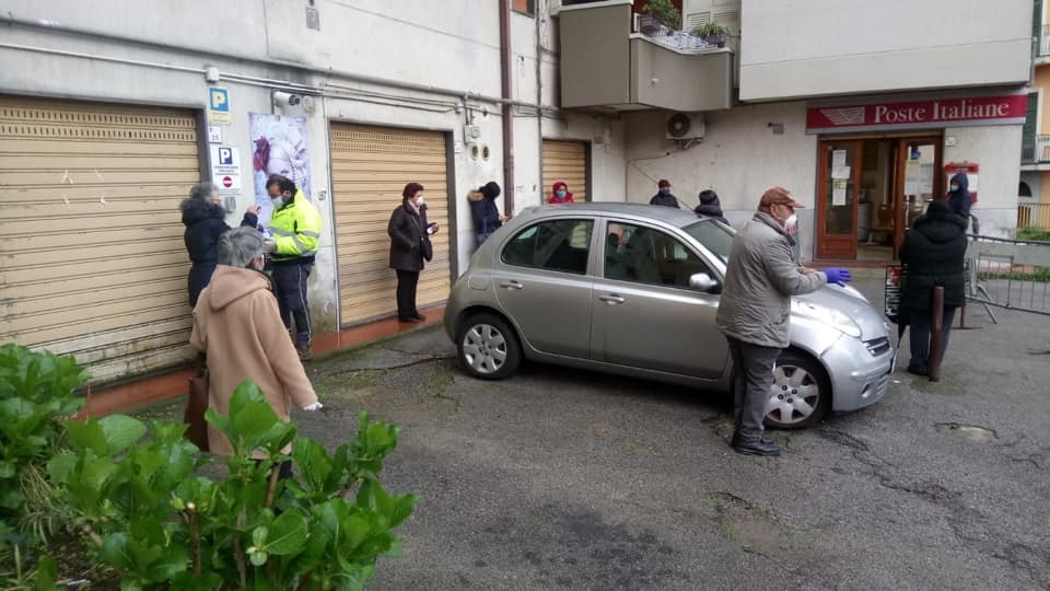 Distribuzione mascherine agli anziani in coda alle poste 